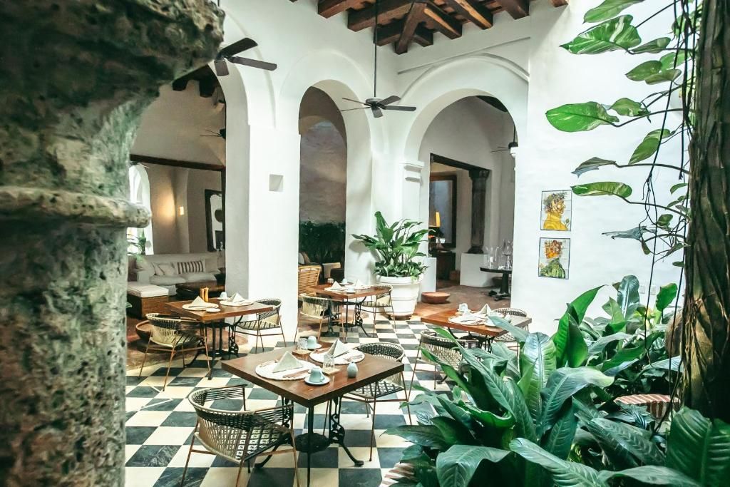 Patio interior de un hotel boutique colonial con mesas de restaurante
